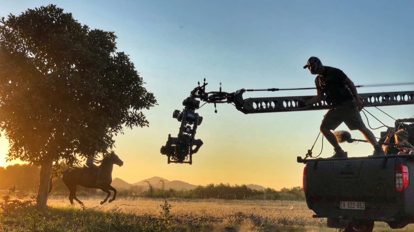 The Black Beauty camera team filming a horse at sunset from a tracking vehicle